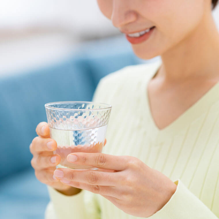 水を飲む　水が入ったコップを持つ　女性