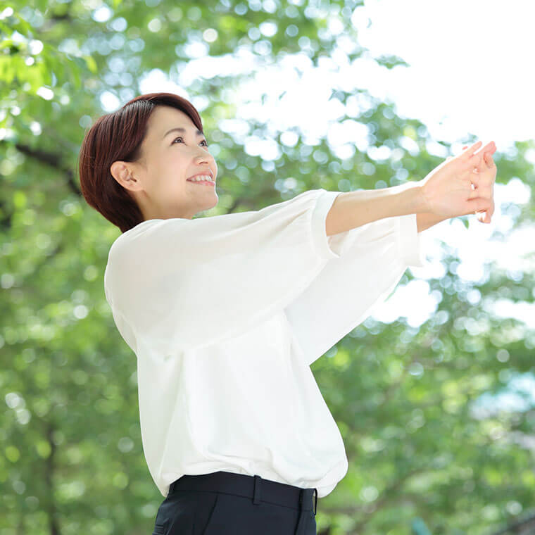 伸びをする女性　屋外散歩