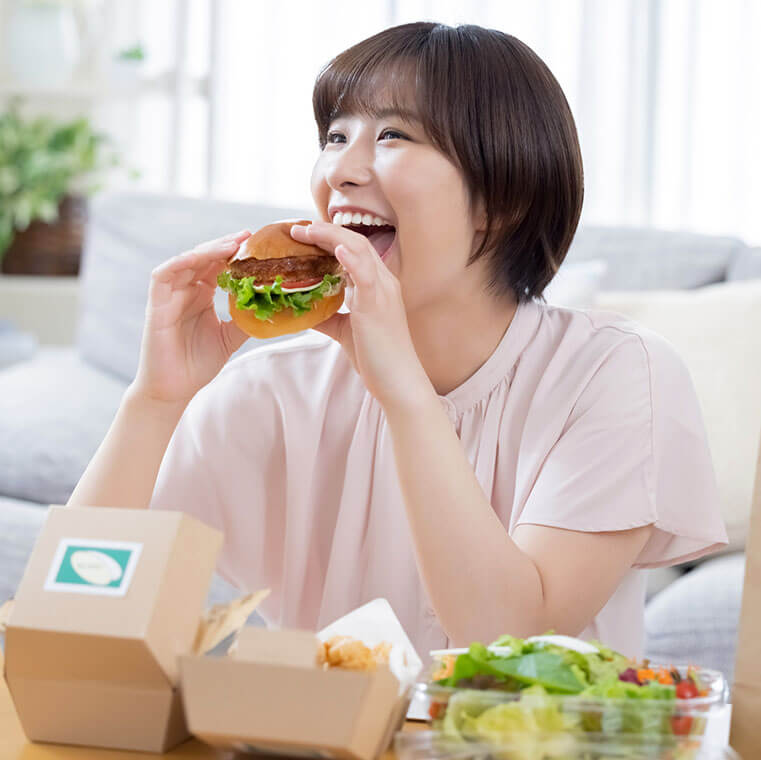 ハンバーガーを食べる女性