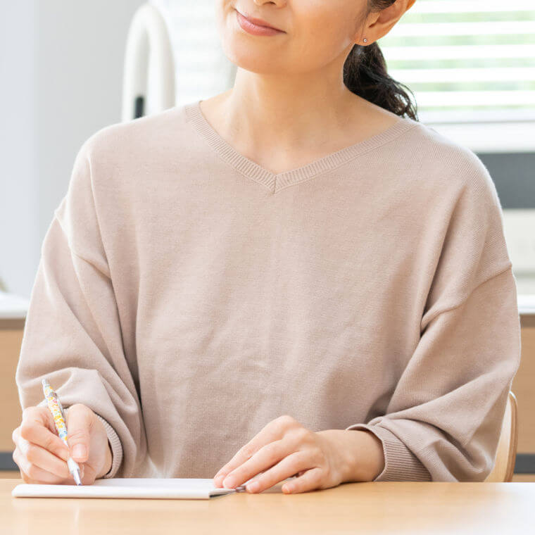 紙に書く女性