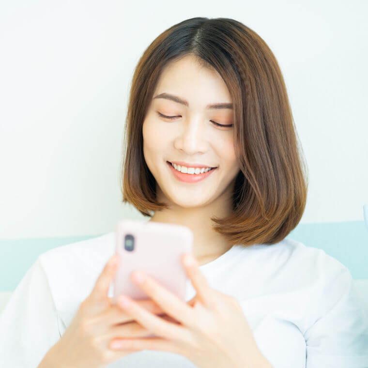 笑顔でスマホを持つ女性