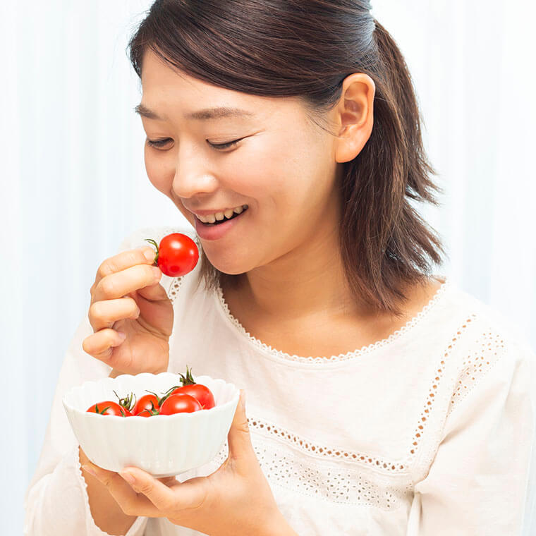 トマトを食べている女性