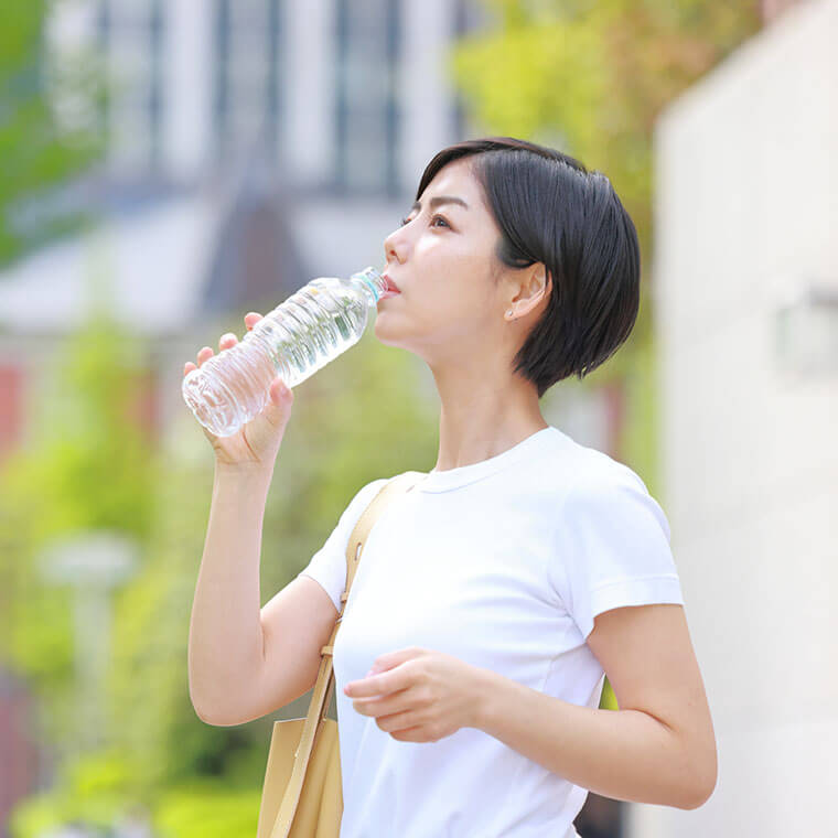 ペットボトルの水を飲む女性