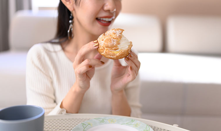 シュークリームを食べる女性