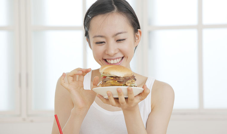 ハンバーガーを食べる女性