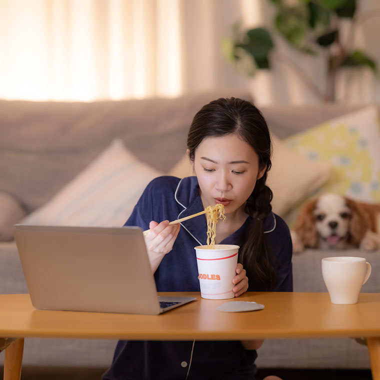 カップ麺を食べる女性