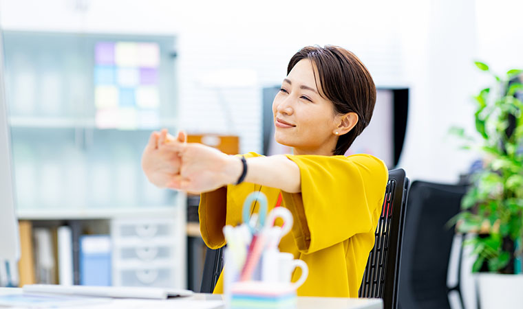 仕事中ストレッチする女性