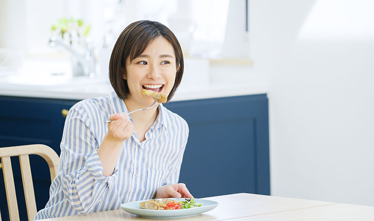 肉料理を食べる女性