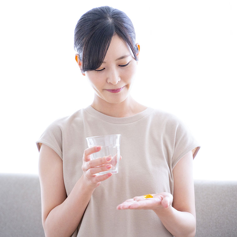 サプリメントを飲む女性