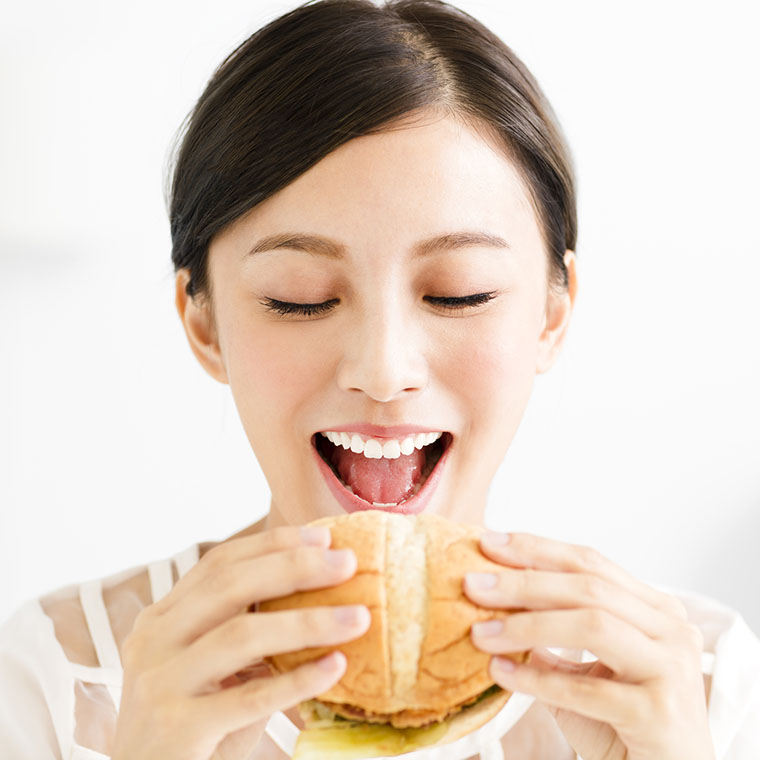 ハンバーガーを食べる女性