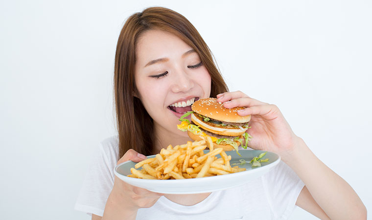 ハンバーガーを食べる女性