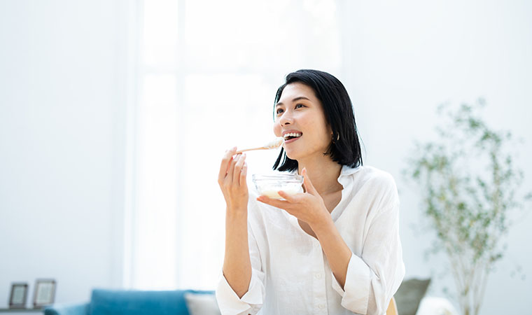 ヨーグルトを食べる女性