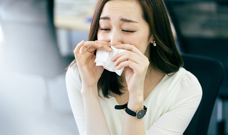 花粉で鼻をかむ女性