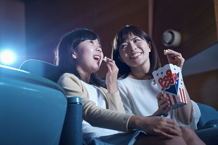 映画館でポップコーンを食べる女性
