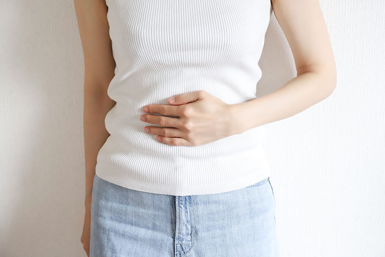 お腹に手をあてる女性