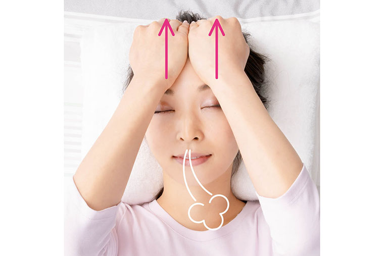 両手でおでこを引き上げる