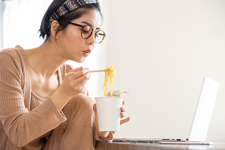 カップラーメンを食べる女性