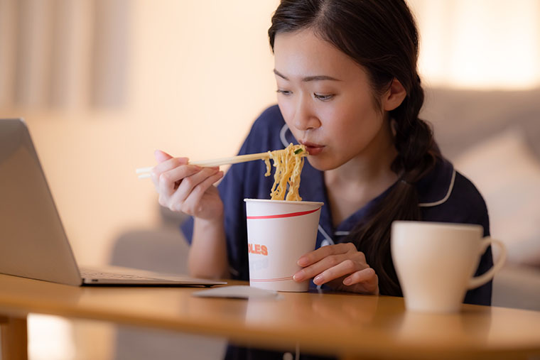 カップラーメンを食べる女性