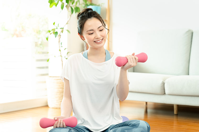 ダンベルで筋トレをする女性