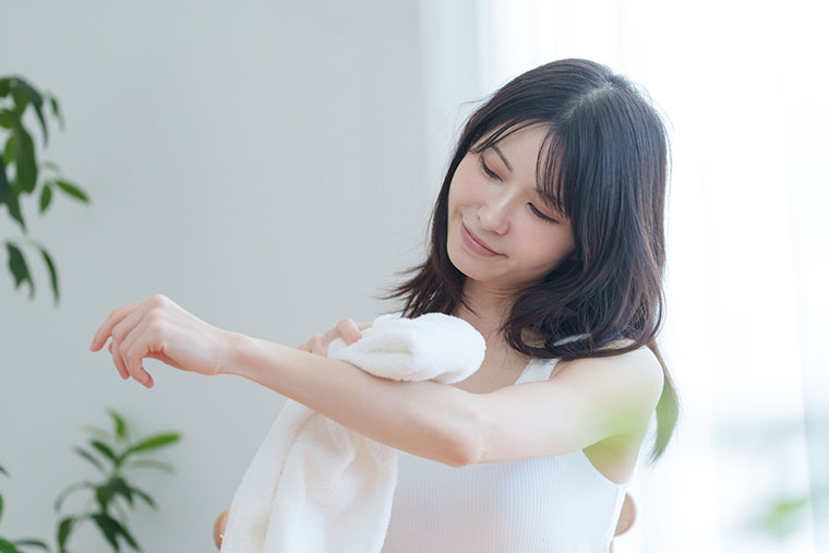 タオルで肌ケアする女性