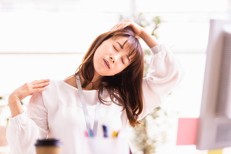 座りながらストレッチをする女性