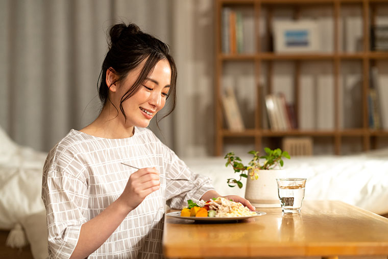 夜に食事をする女性
