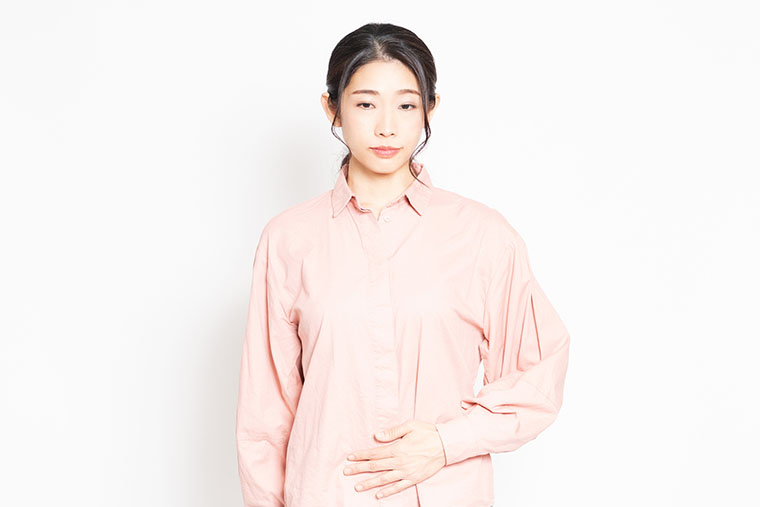 お腹に手をあてる女性