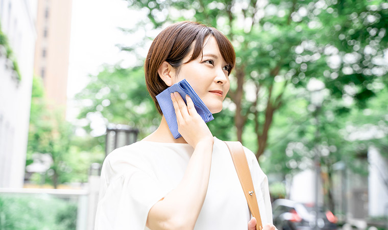 外で汗をふく女性