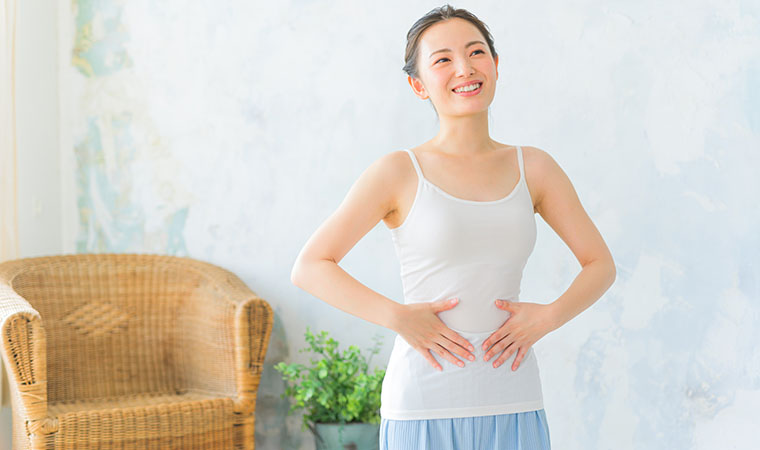 お腹に手をあてる女性