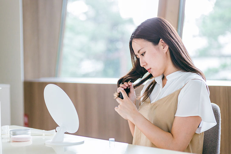 枝毛を気にする女性