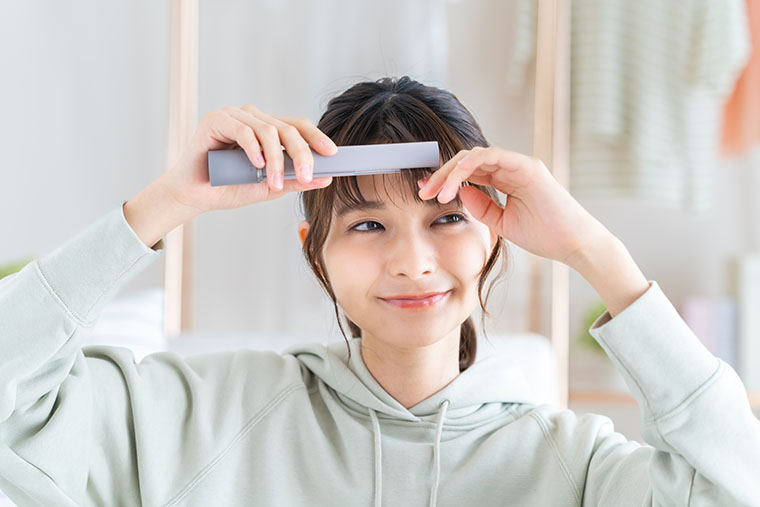 ストレートアイロンを使う女性