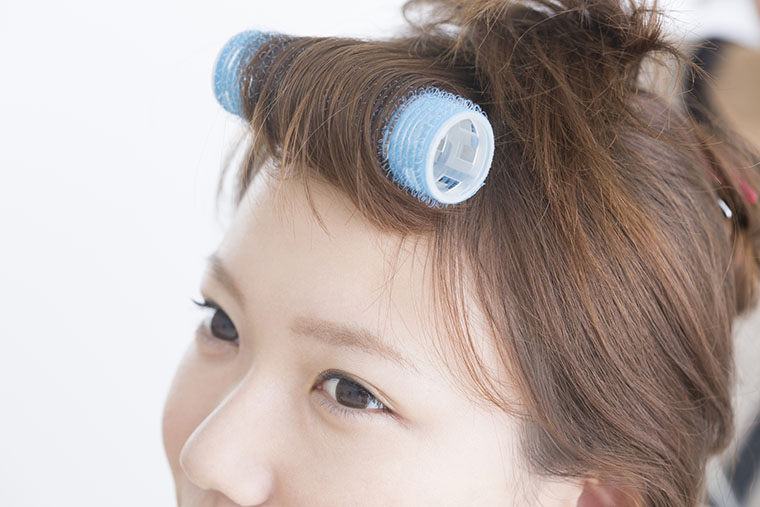 カーラーを使う女性