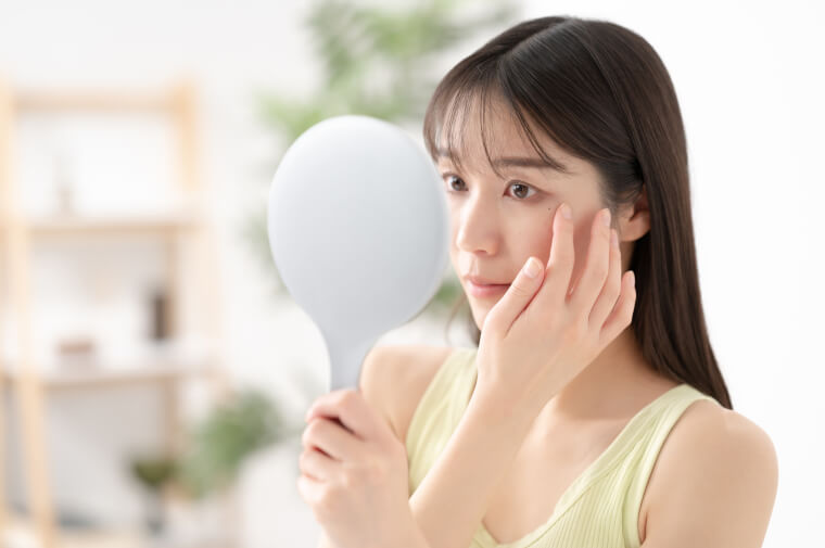 鏡で目を見る女性