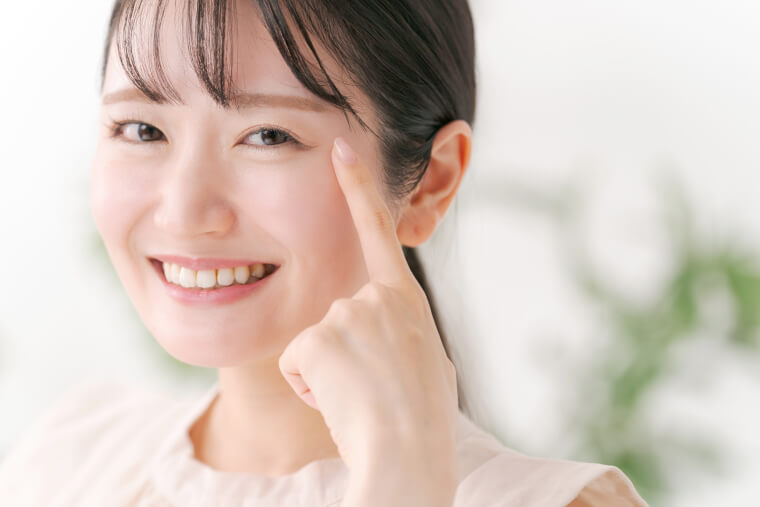 目を指差す女性