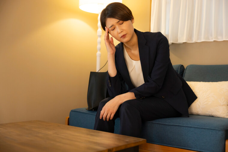 こめかみをおさえる女性