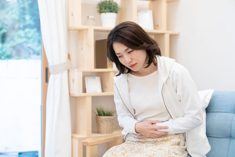 お腹を抑える女性