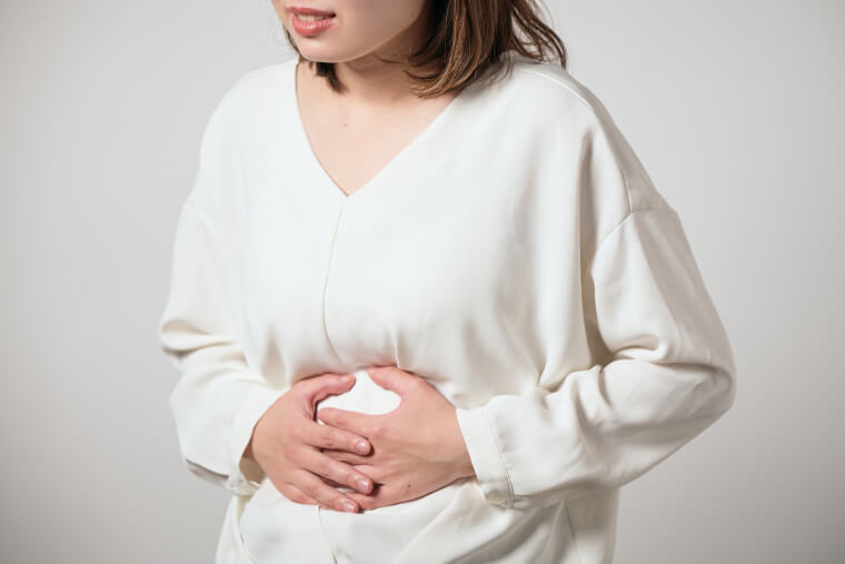 お腹を抑える女性