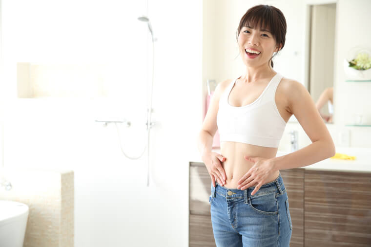 お腹を触る笑顔の女性