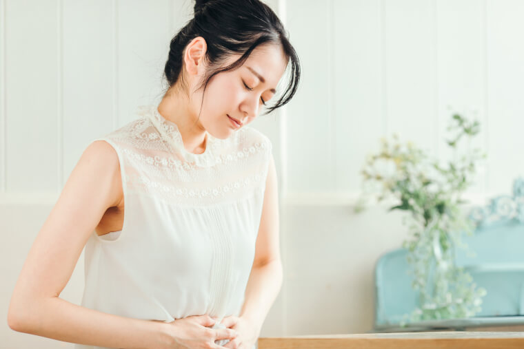 お腹をおさえる女性
