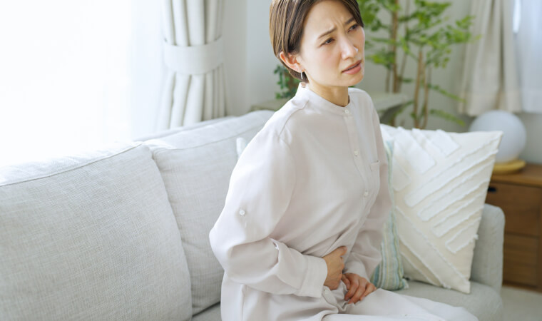 お腹をおさえる女性