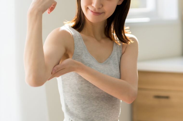 二の腕に触れる女性