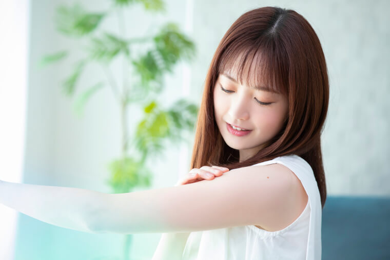 二の腕に触れる女性