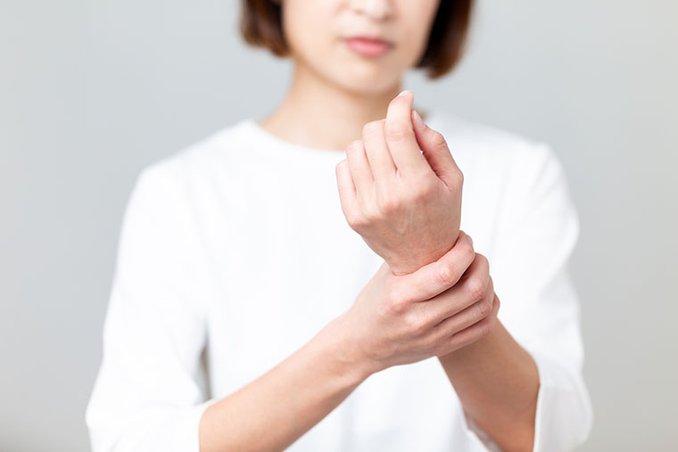 手首をおさえる女性