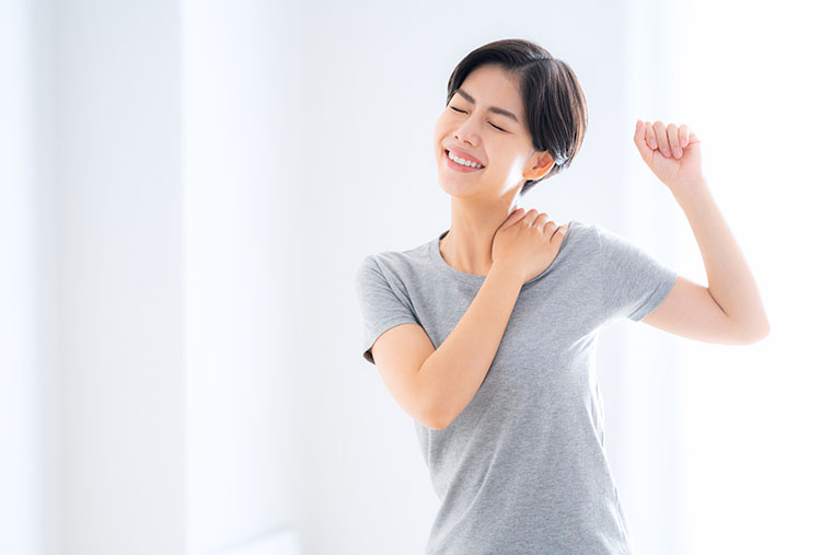 肩のストレッチをする女性