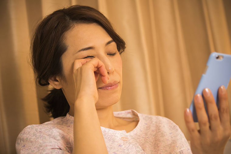 夜に目を擦る眠い女性
