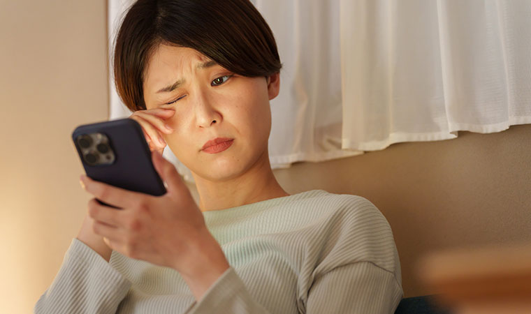 夜に目を擦る眠い女性