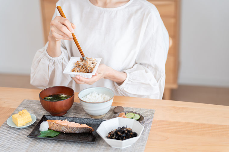 朝食の納豆を混ぜる女性