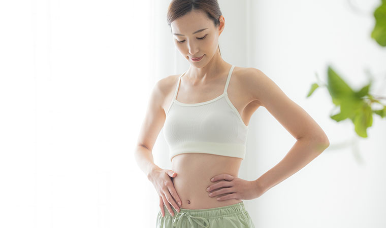 お腹に手をあてる女性