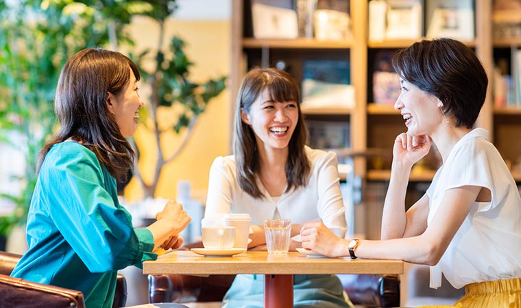 カフェで友人たちと話す女性