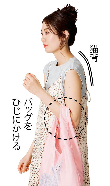 バッグを腕にかける猫背な女性